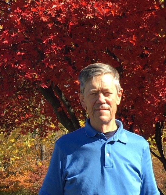 Photo of Ted Bergh against red autumn foliage.